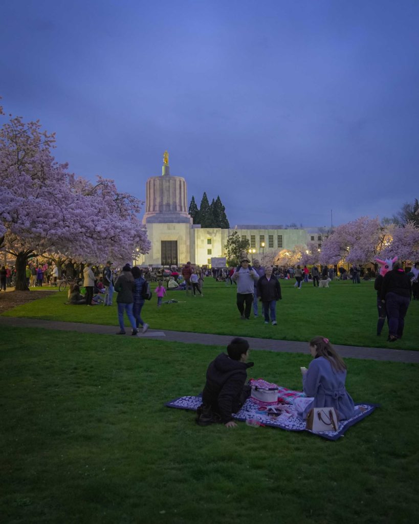 People on the capitol mall at night for the Cherry Blossom Festival in Salem, Oregon.