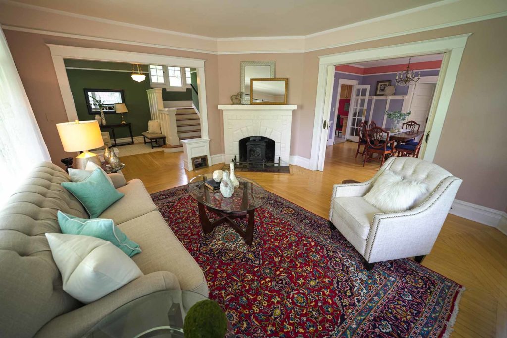 Living room of century-old house with a couch, chair, and fireplace