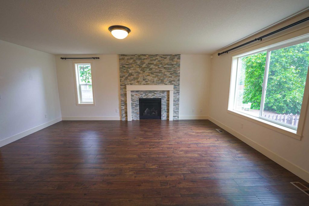 A large, open living room with a fireplace at one end in a modern home