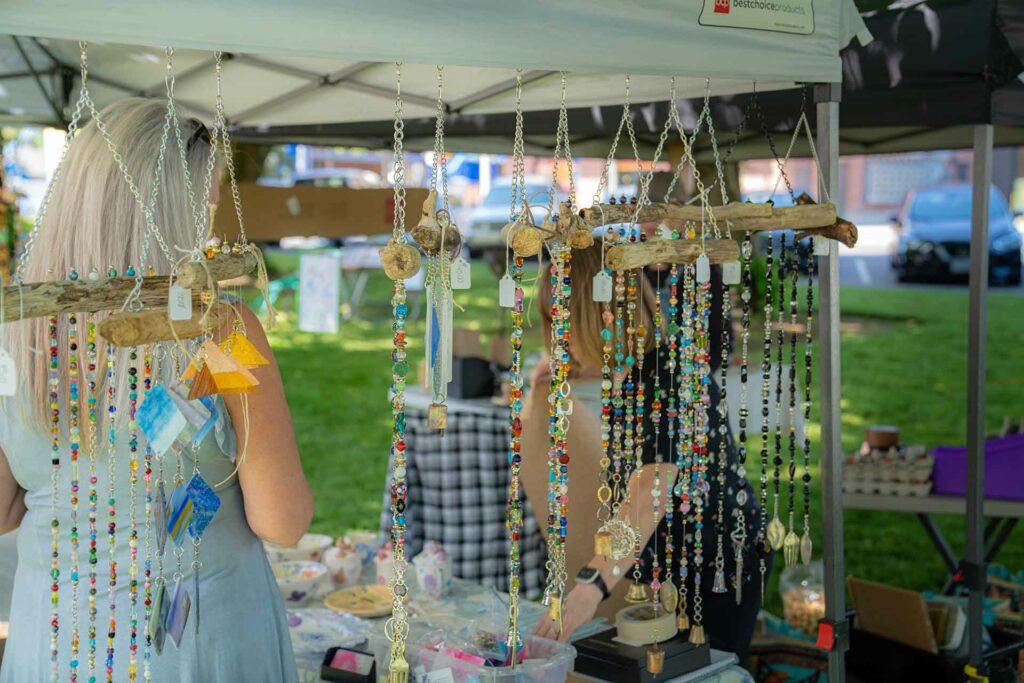 Necklaces hanging from a booth at a festival.